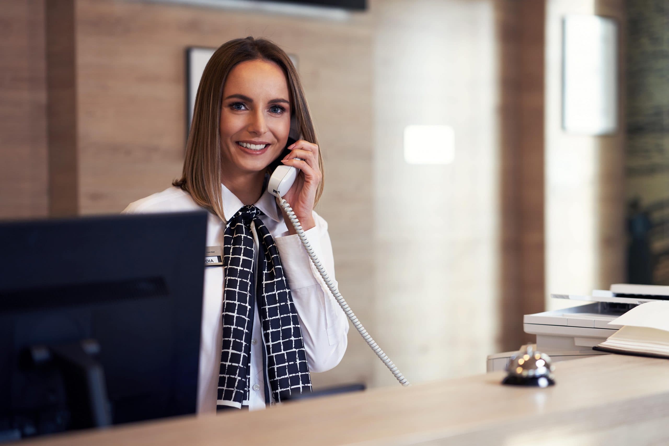 Hotel front desk receptionist answering a call